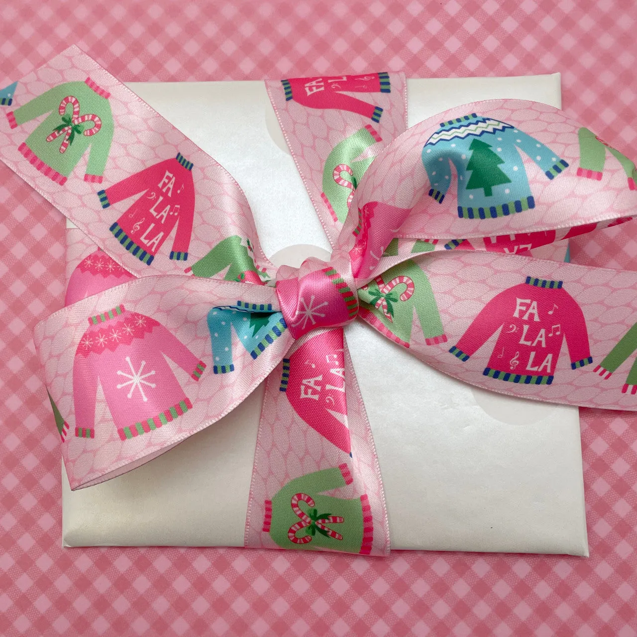 Christmas Ribbon Sweaters in pastel colors on a pink knit background printed on 1.5" white satin